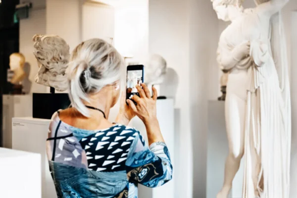 Woman Taking Picture Of Classical Sculpture